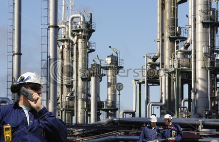 stock-photo-engineer-talking-in-mobile-phone-in-front-of-large-oil-and-gas-refinery-industry-concept-two-10471729.jpg